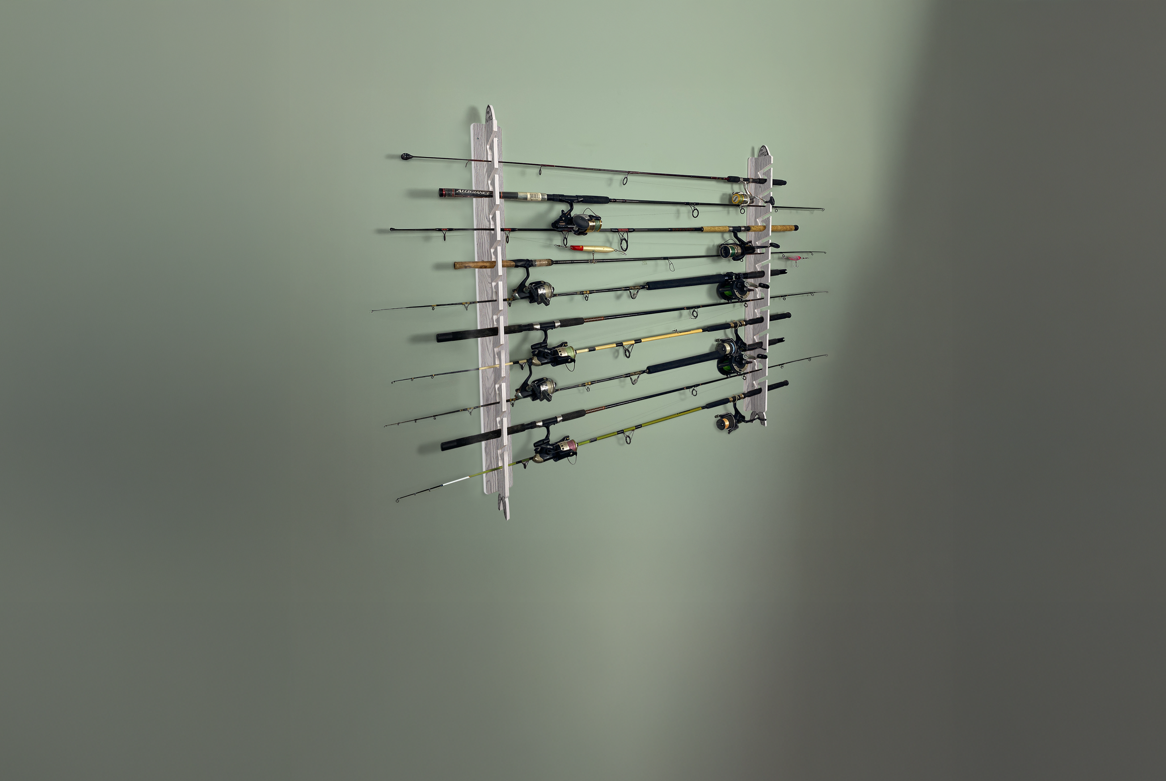 Wall-mounted fishing rod holder with multiple fishing rods on a plain wall.
