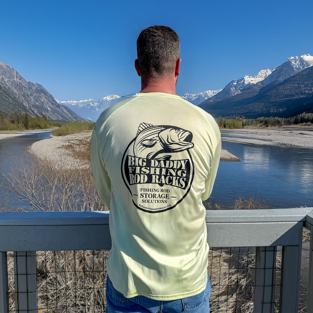 man looking at a lake in a yellow shirt