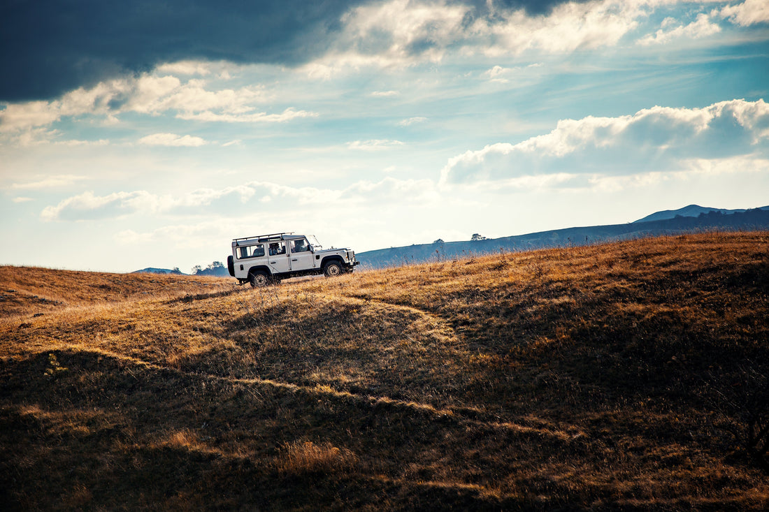 Jeep climbing up rugged mountain terrain.