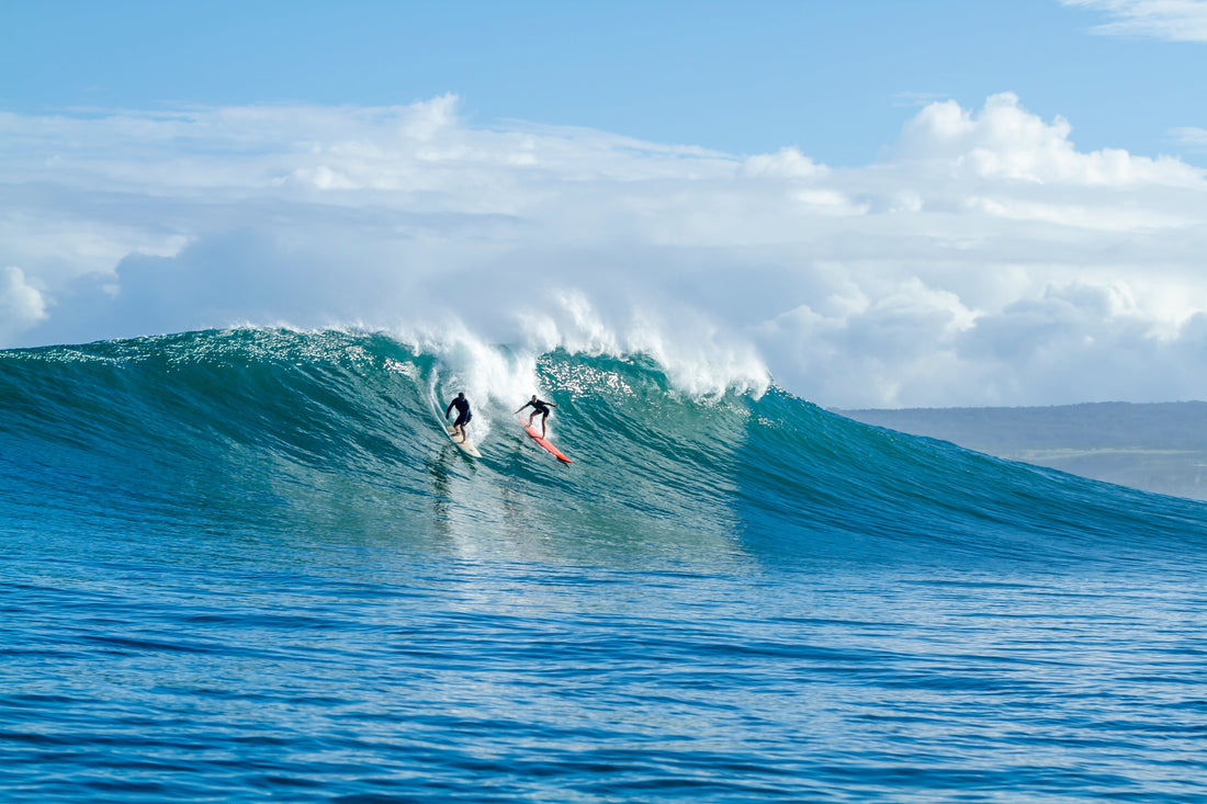 A man and woman riding the same wave