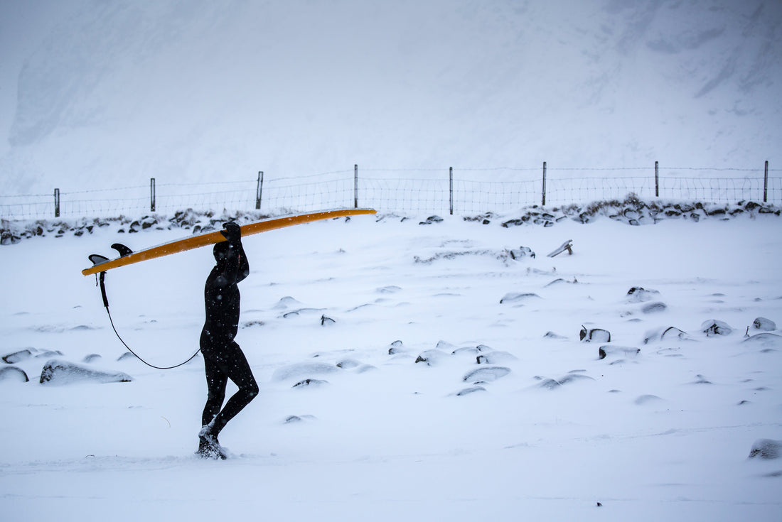winter surfing on a snow covered beach