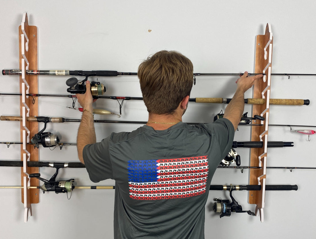 man putting fishing rod into a teak big daddy life fishing rod rack