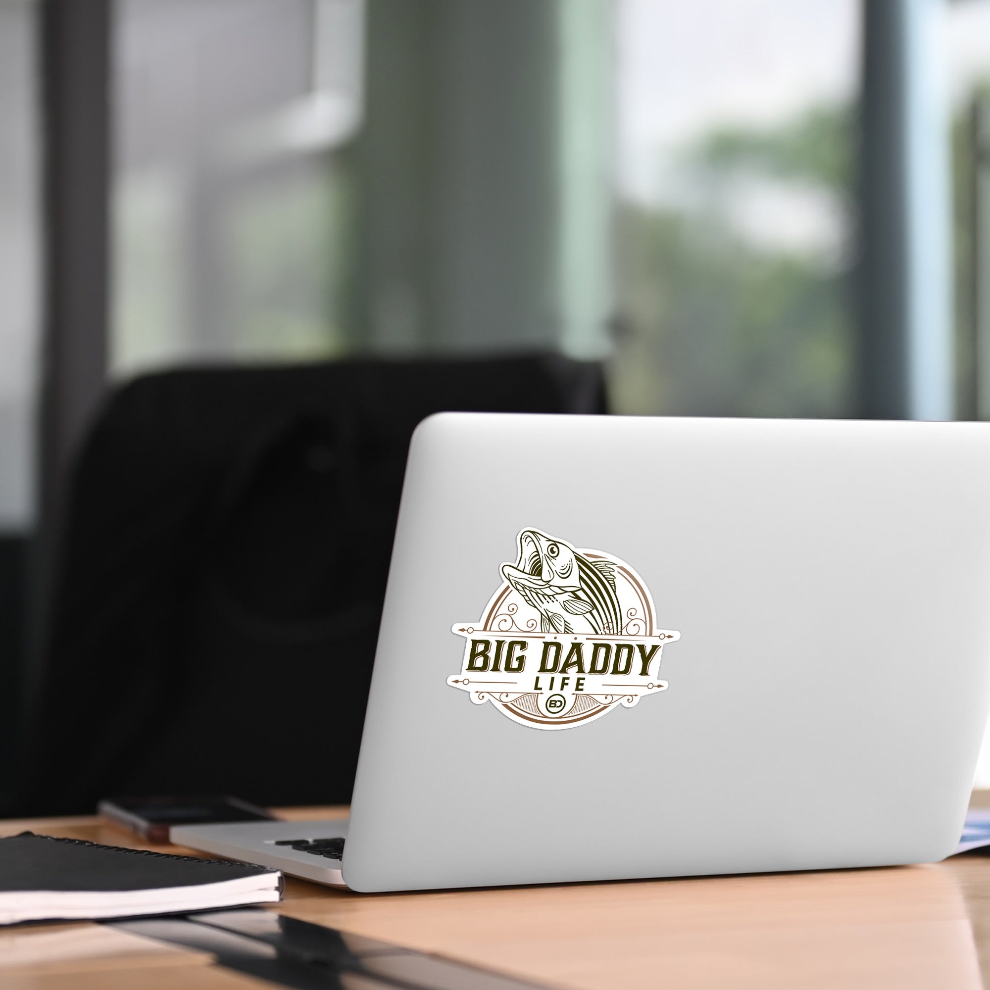 Laptop with 'Big Daddy Life' sticker on a desk in an office setting