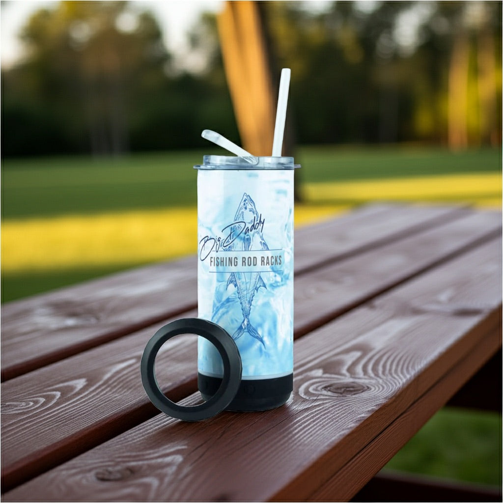 Tumbler with a fish design on a wooden table outdoors