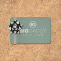 Big Daddy e-gift card with a decorative bow on a cork background