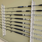 Wall-mounted fishing rod holder with multiple fishing rods on a beige wall.